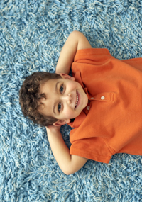 Boy Lying on Carpet --- Image by © Royalty-Free/Corbis